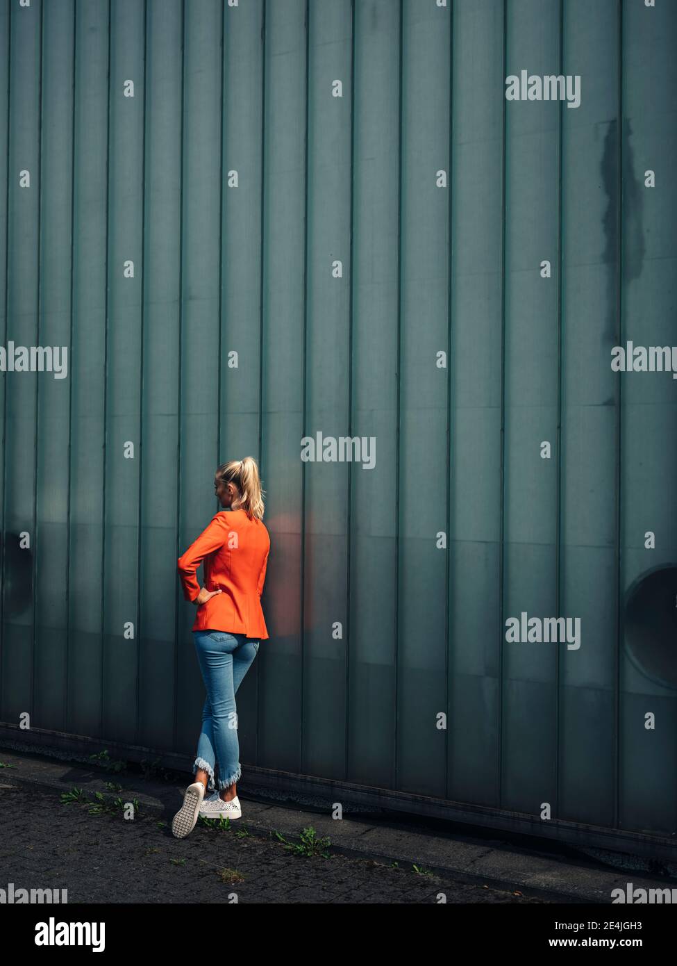Donna in piedi per muro sul sentiero Foto Stock