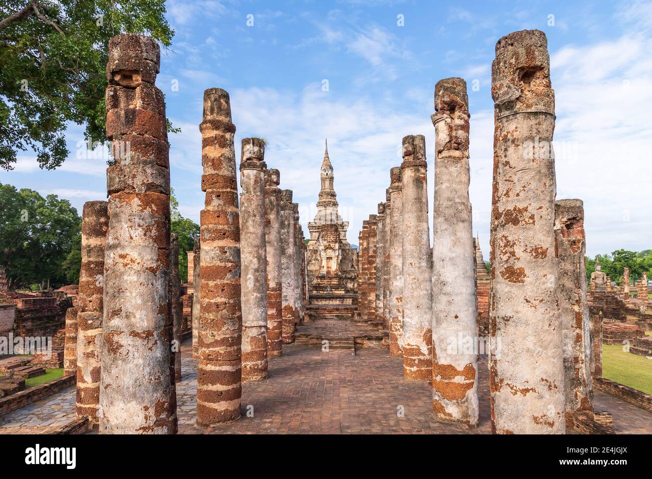Fila di colonne in cappella in rovina e pagoda nel complesso del monastero al tempio di Wat Mahathat, Sukhothai Historical Park, Thailandia Foto Stock