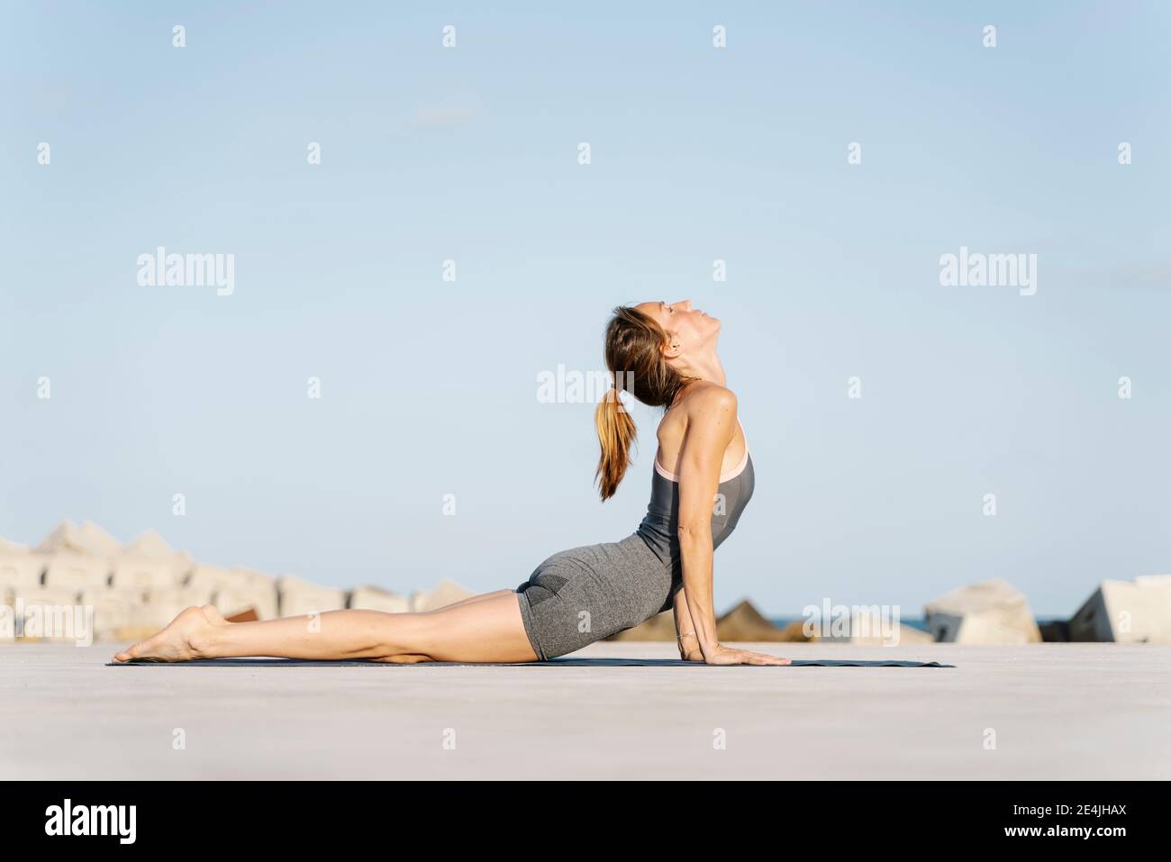 Sportivo femminile che fa posa cobra su materassino da sforzo Foto Stock