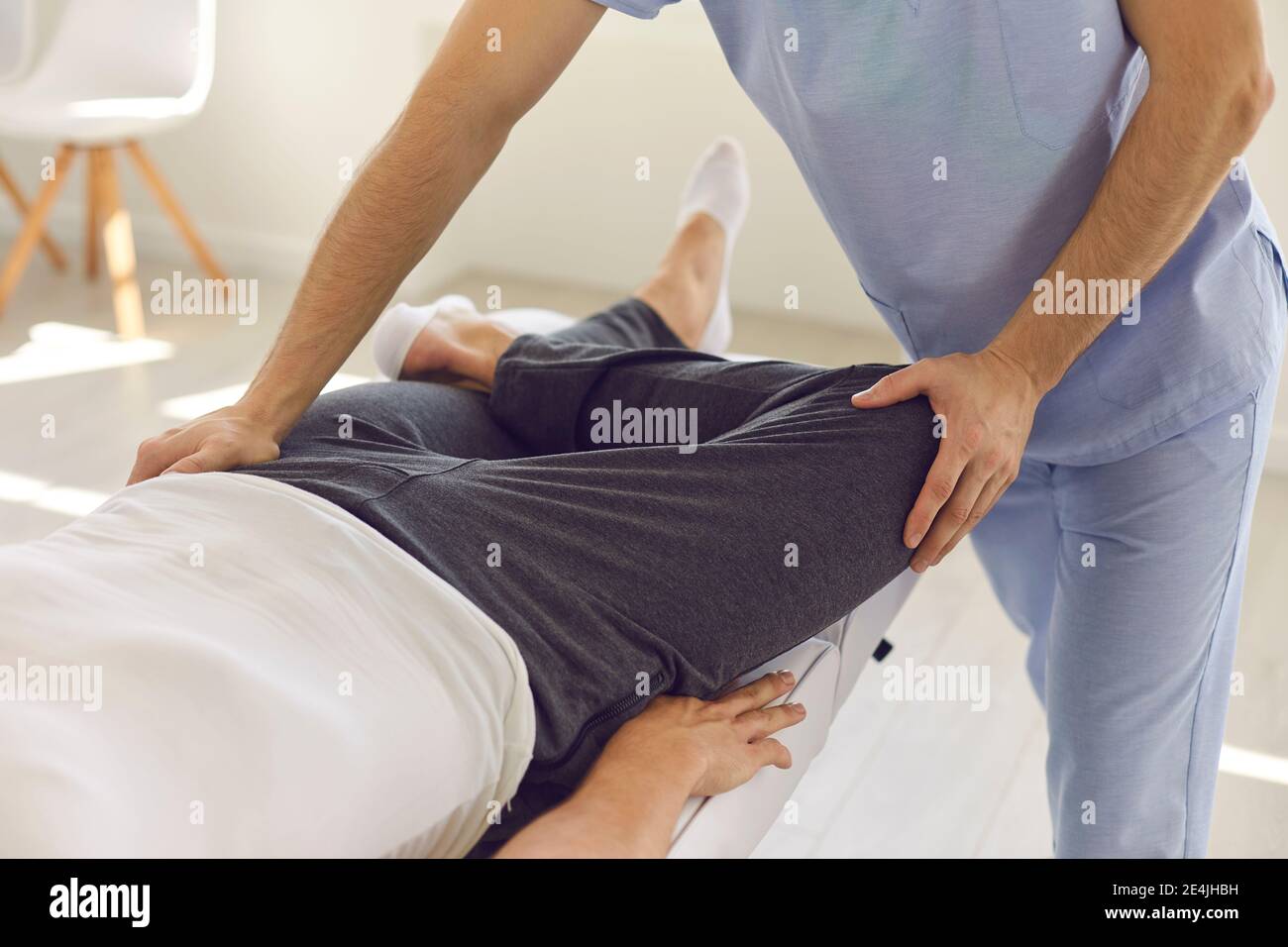 Mani di uomo professionale osteopata che fissa l'uomo pazienti ginocchio e. articolazioni delle gambe Foto Stock