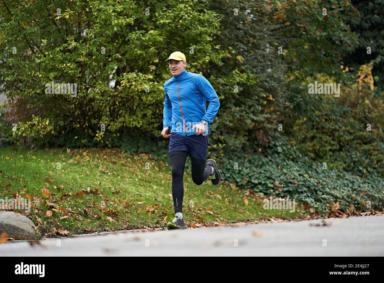 Uomo maturo in abbigliamento sportivo che corre sul sentiero da erba Foto Stock