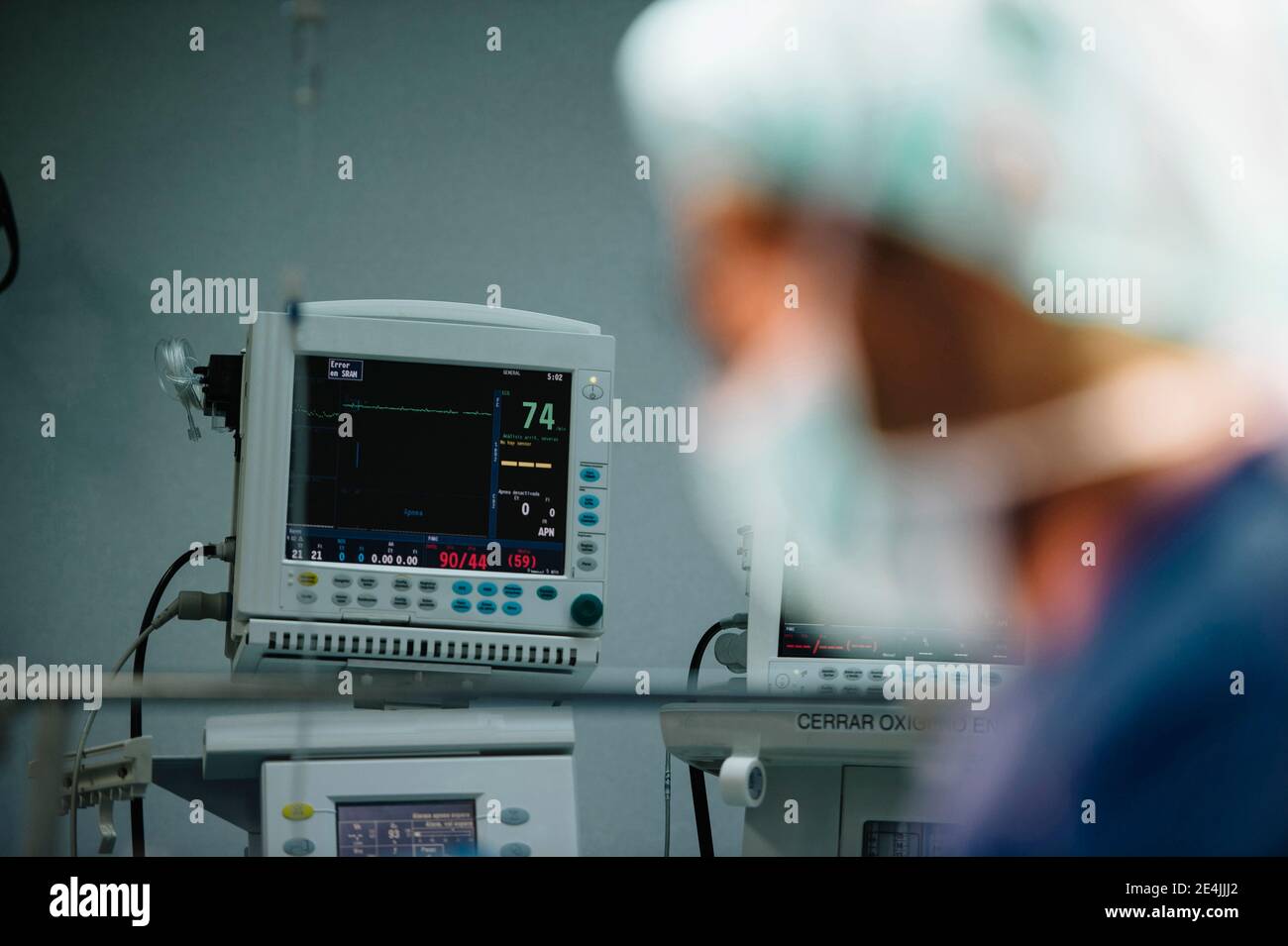 Chirurghi maschili visti dal vetro durante l'esecuzione di operazioni in ospedale Foto Stock