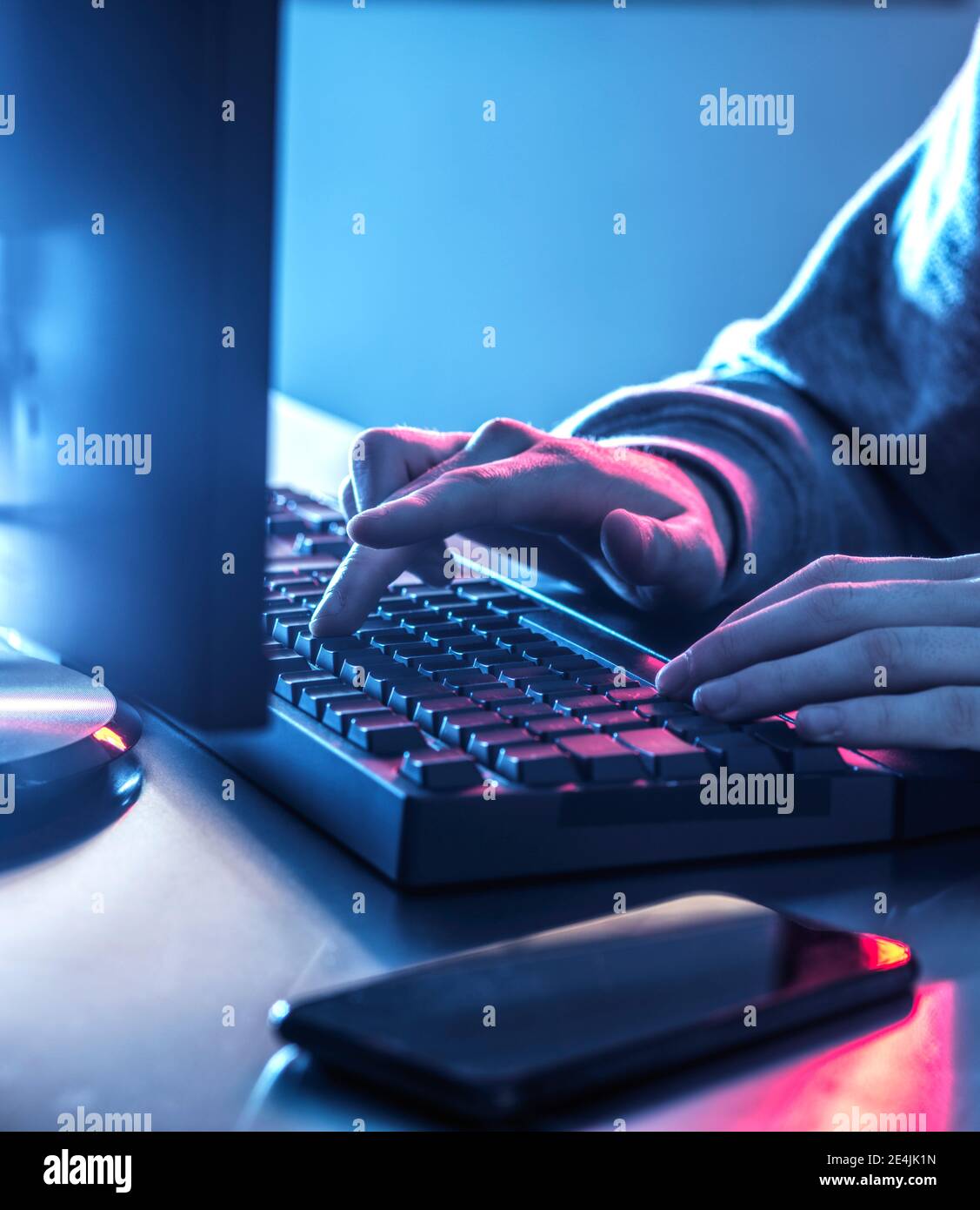 Mani di ragazzo adolescente hacking computer sulla scrivania Foto Stock