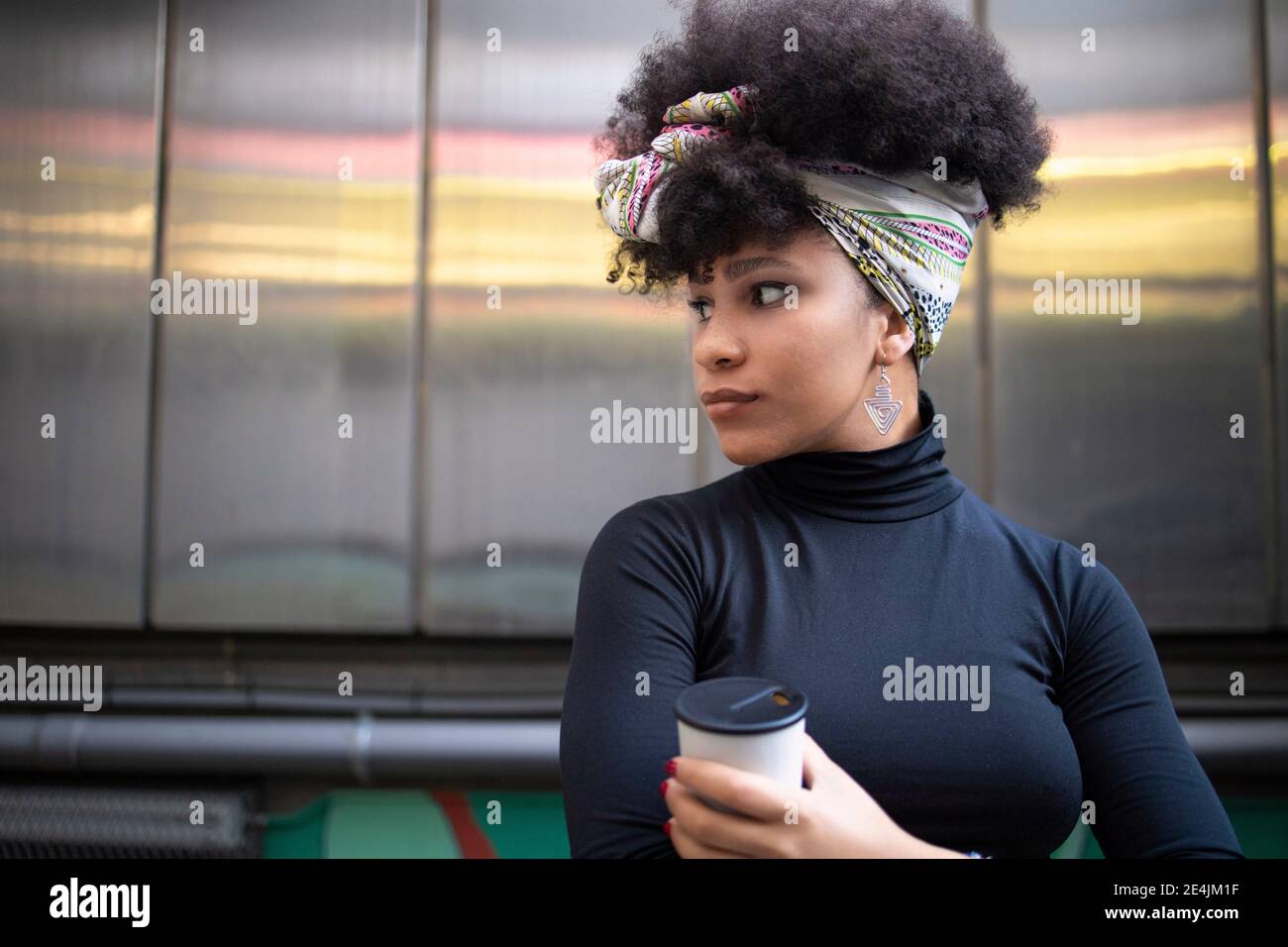 Afro giovane donna che indossa la fascia in città Foto Stock