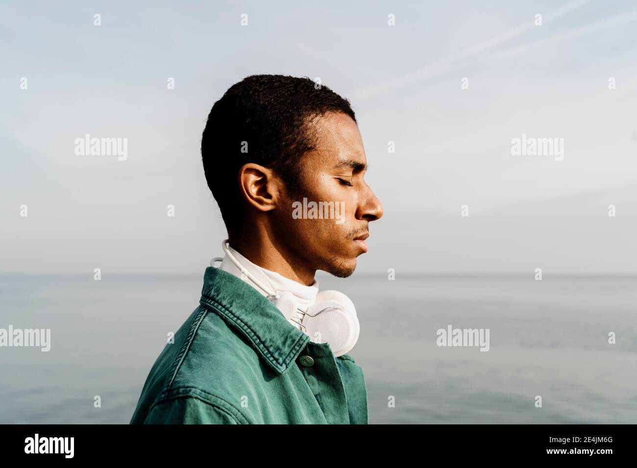 Uomo con gli occhi chiuso giorno sognando dal mare Foto Stock