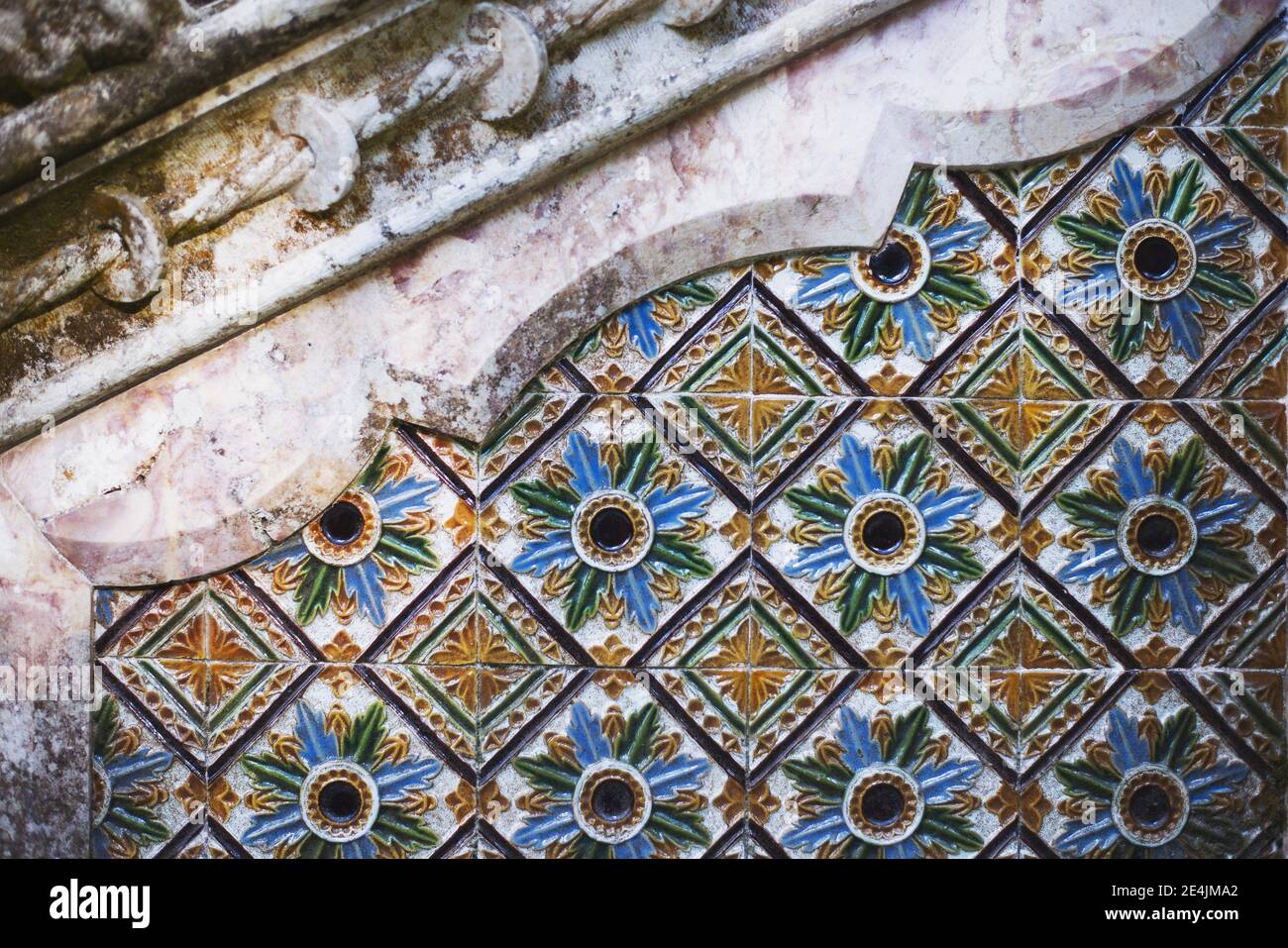 le piastrelle colorate si incontrano con le complesse pietre Foto Stock