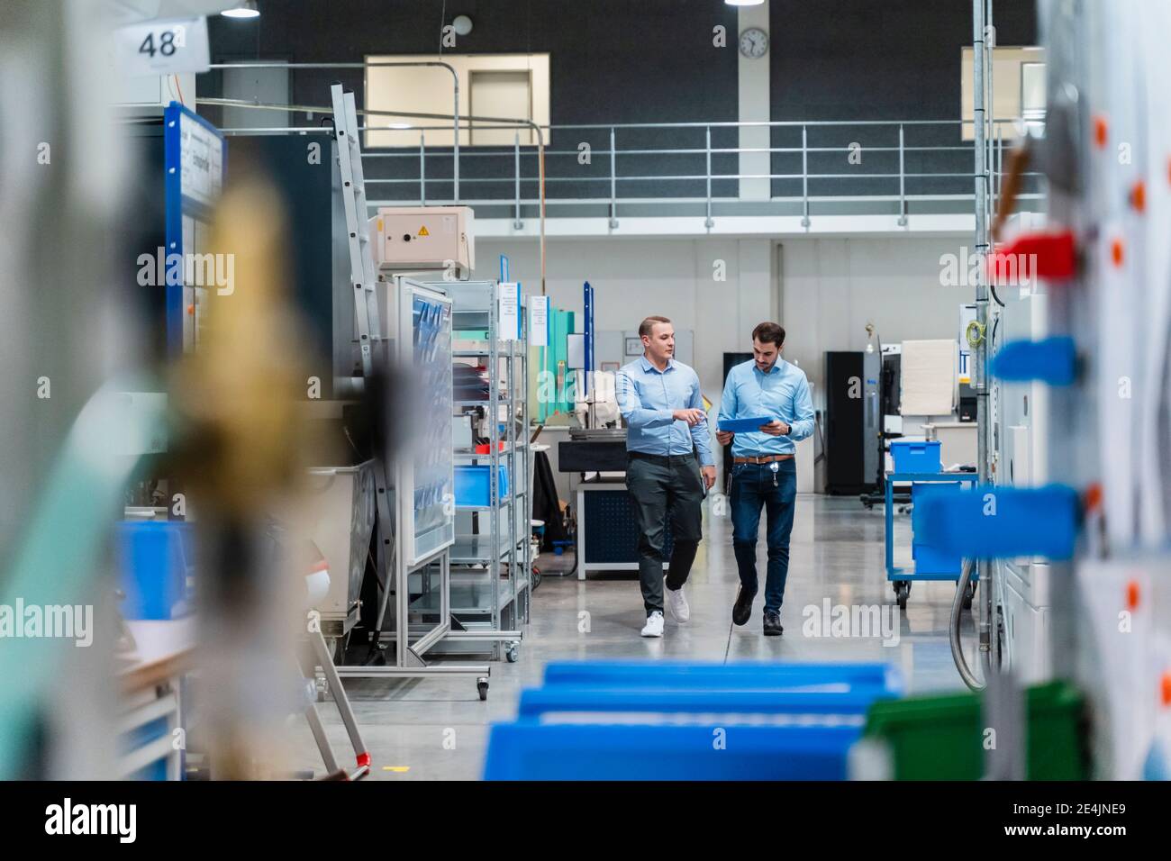 Gli uomini d'affari discutono sopra il documento mentre camminano alla fabbrica Foto Stock