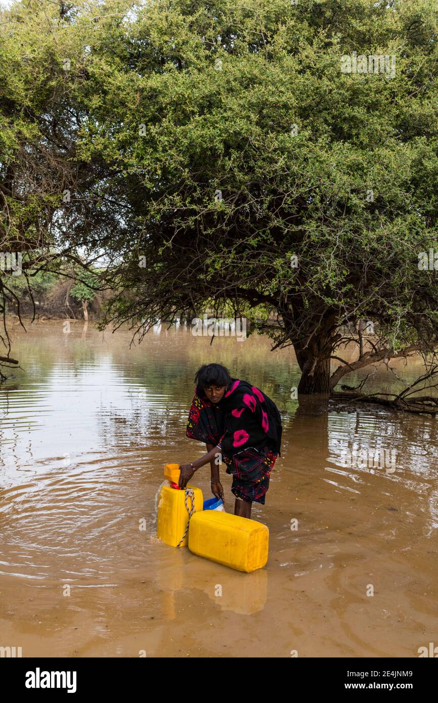 Donna incetta l'acqua in canister, Niger Foto Stock