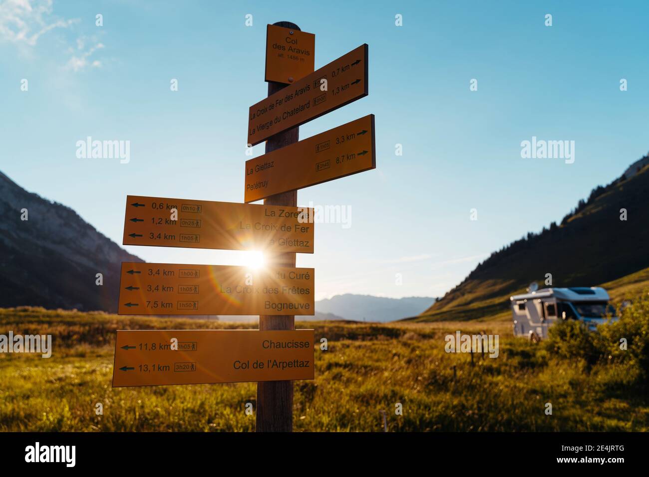Cartelli che indicano percorsi di montagna con casa a motore durante il tramonto al col des Aravis;Haute-Savoie, Foto Stock