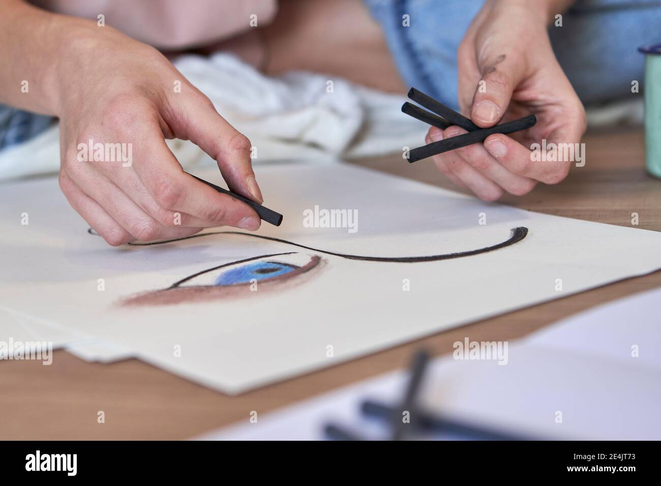Artista femminile che fa disegno di carbone su carta in soggiorno Foto Stock