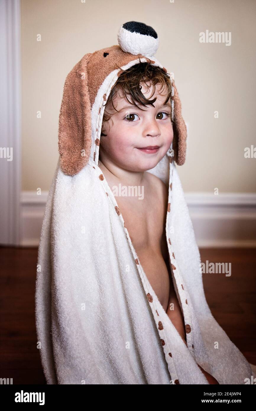 Bambino seduto sul letto Foto Stock