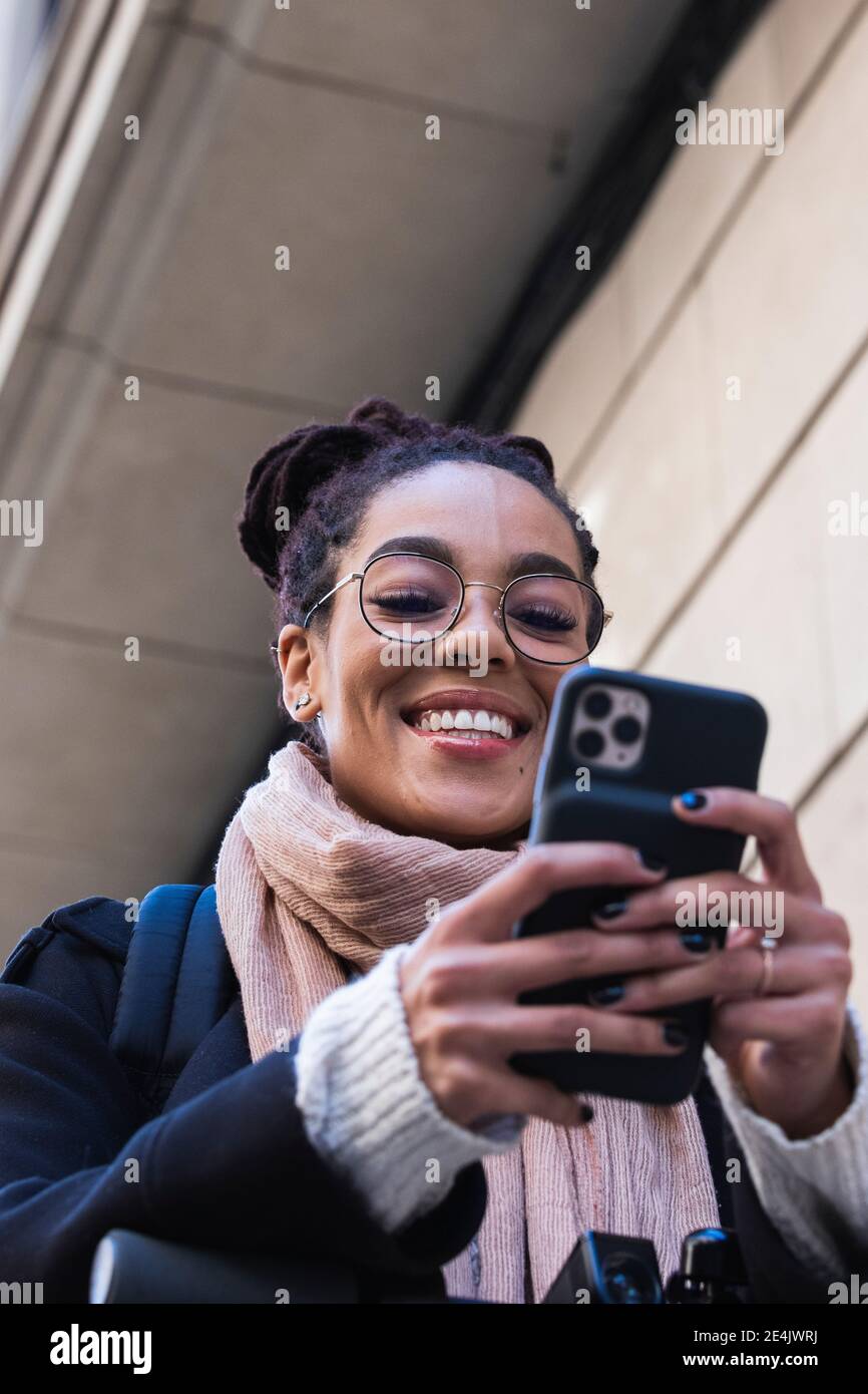 Sorridente bella giovane donna con smartphone Foto Stock