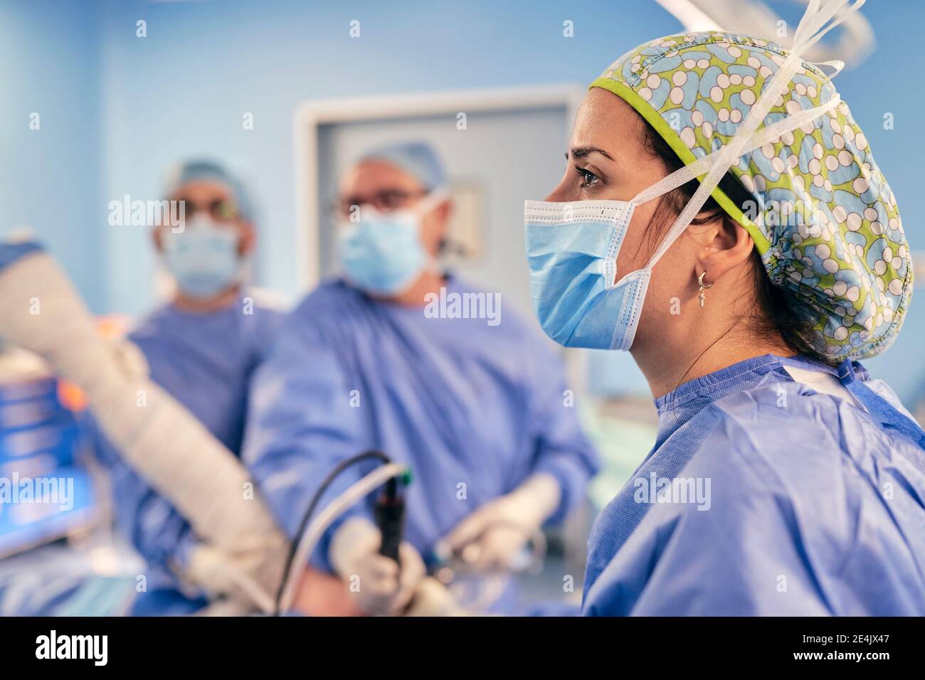 Donna medico indossare maschera protettiva viso in piedi con collega in sala operatoria in ospedale Foto Stock