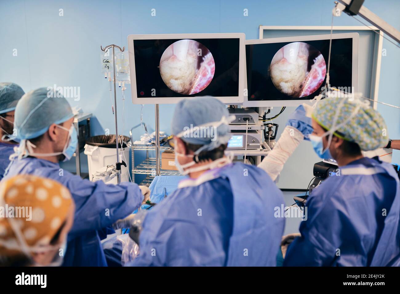 I medici monitorano l'intervento chirurgico sullo schermo del computer mentre sono in funzione camera durante COVID-19 Foto Stock