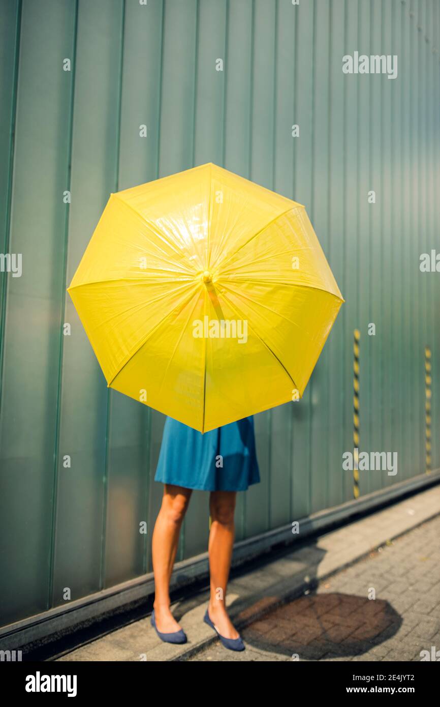 Donna che tiene l'ombrello in piedi sul sentiero durante la giornata di sole Foto Stock