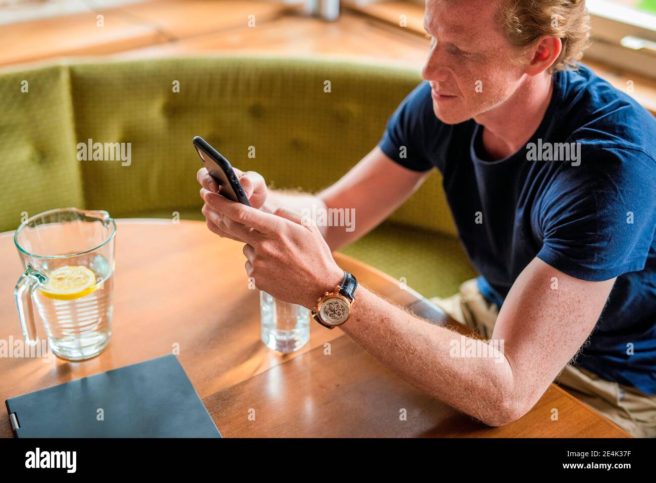 Messaggi di testo uomo mid adult sul telefono cellulare in vita camera Foto Stock