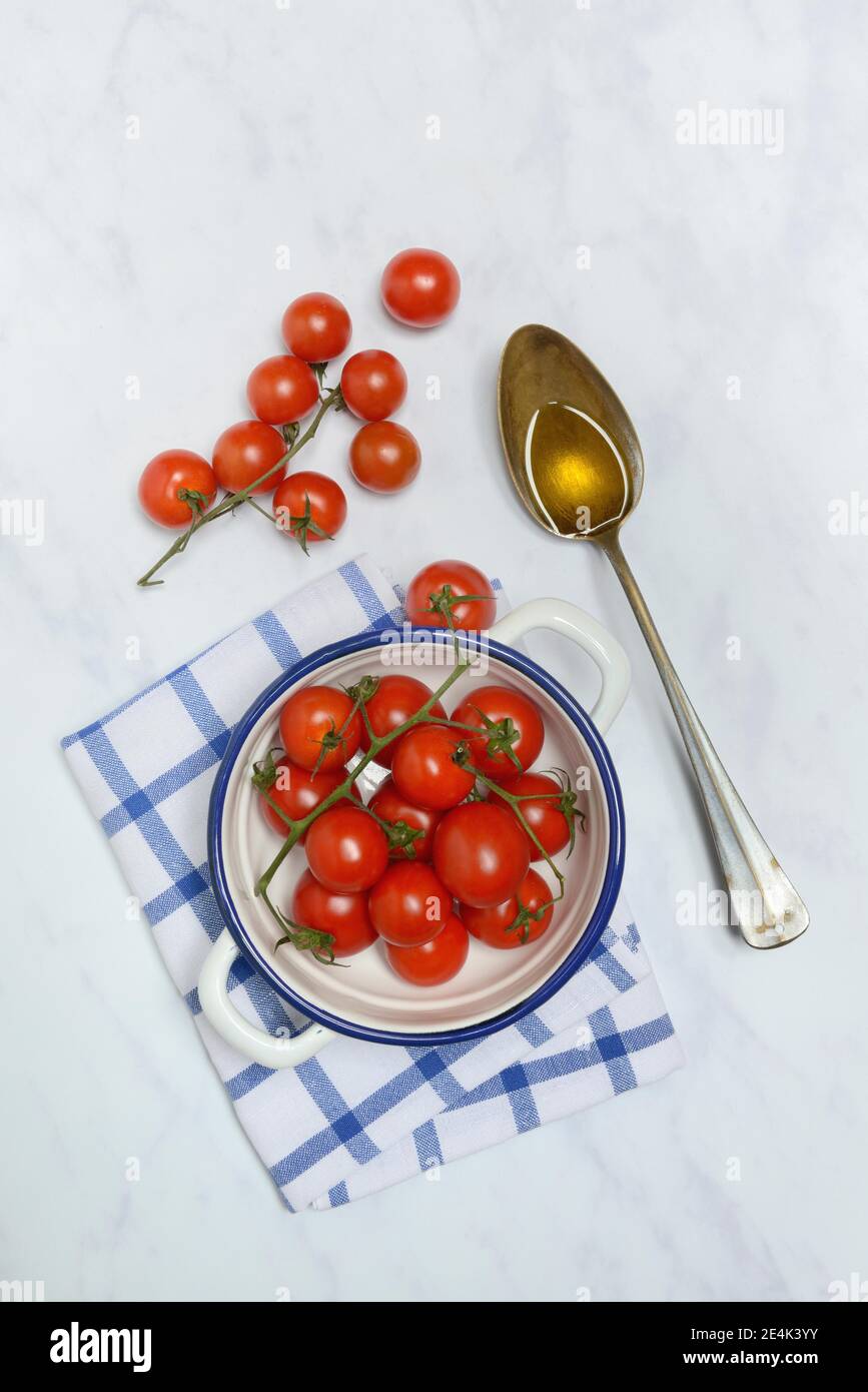 Pomodori ciliegini in buccia e cucchiaio con olio d'oliva, lycopersicum di Solanum, pomodori ciliegini, pomodori ciliegini Foto Stock