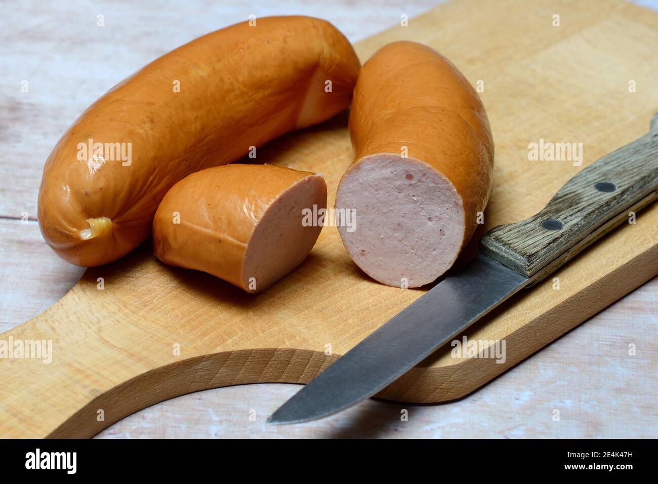 Salsiccia di carne a fette su tavola di legno, Swiss Cervelat Foto Stock