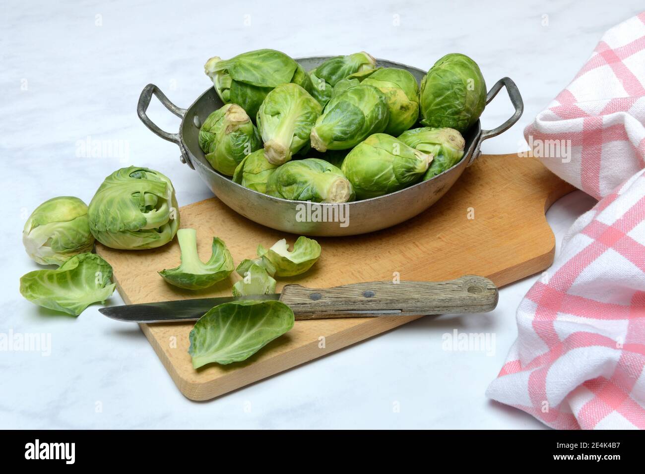 Bruxelles germogli in una ciotola con coltello da cucina, Brassica oleracea gemmifera Foto Stock