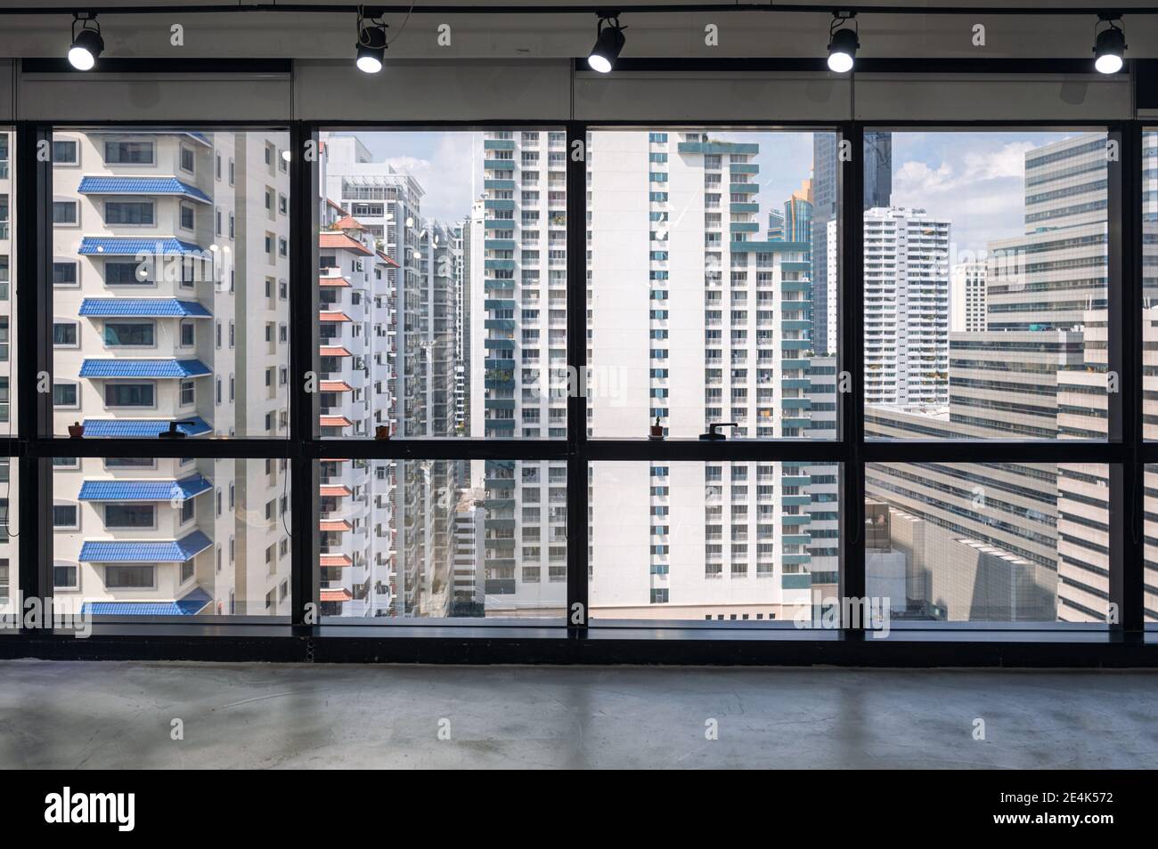 Ufficio interno con finestra e affollato edificio in centro a. quartiere degli affari Foto Stock