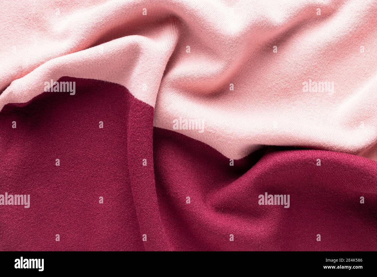 tessuto lavorato a maglia rosa e bordeaux con pieghe. Maglieria di moda Foto Stock