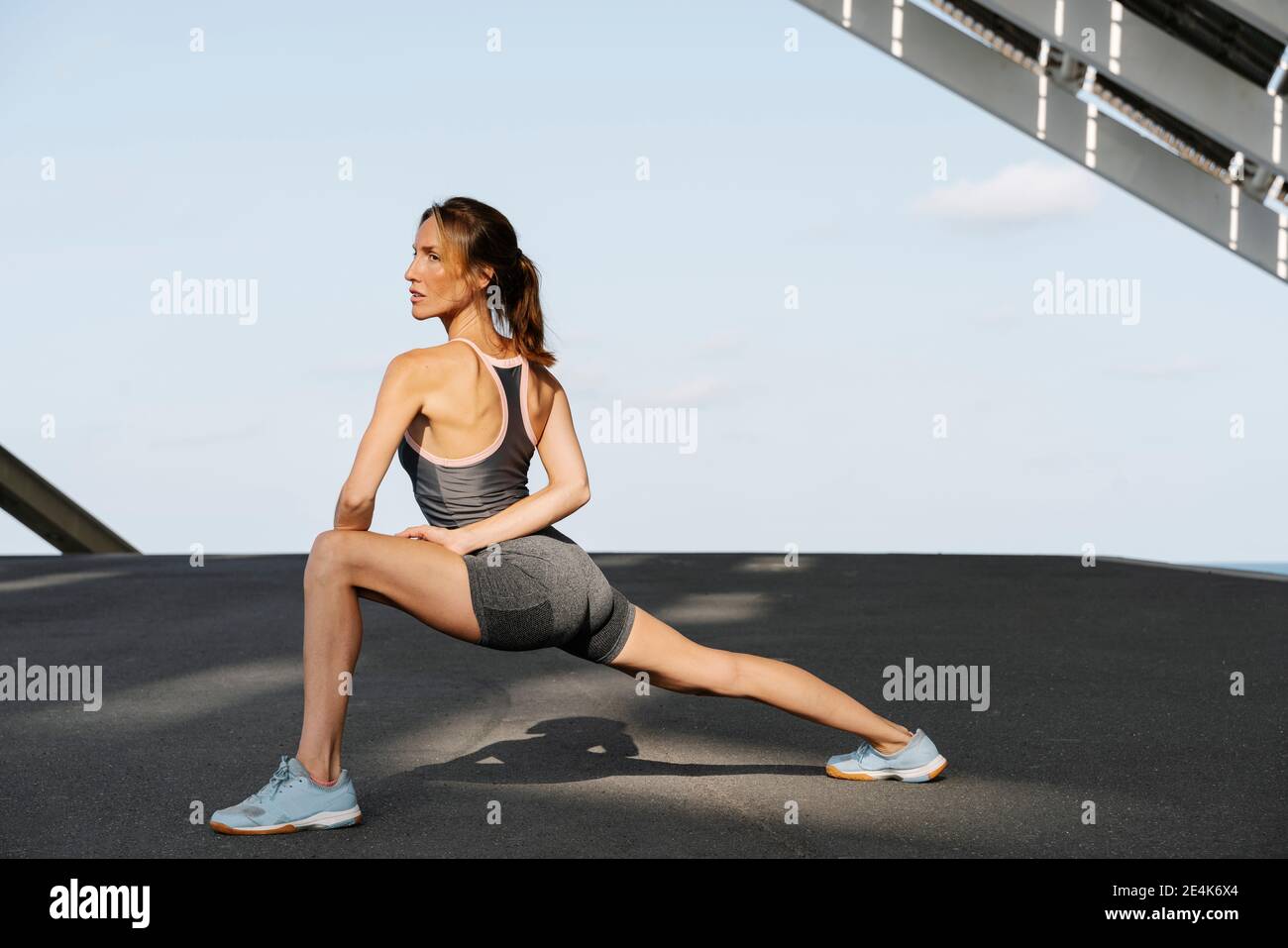Gambe sportive medio adulte che si allungano in una giornata di sole Foto Stock