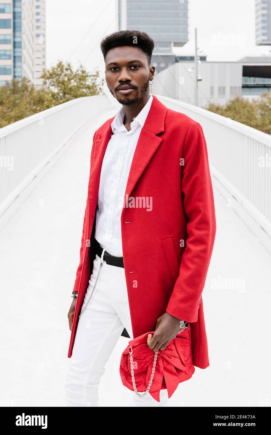 Uomo elegante che indossa una giacca rossa mentre si è in piedi sul ponte  Foto stock - Alamy