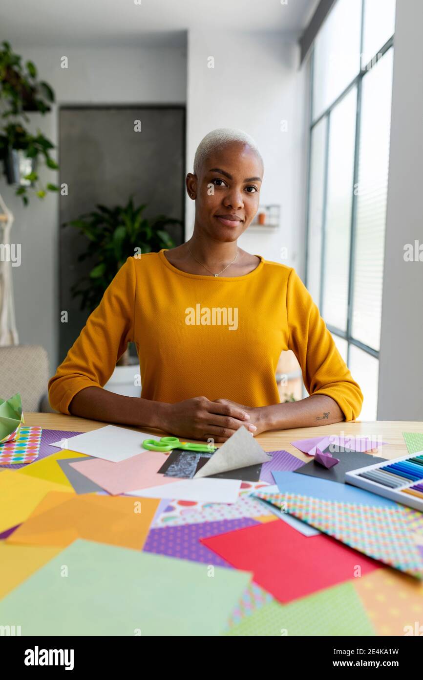 Artista Origami seduto in studio con carte colorate Foto Stock