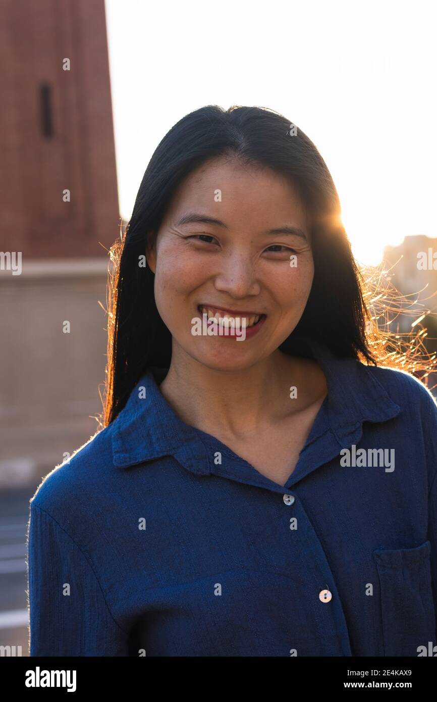 Donna sorridente contro il cielo durante il fine settimana Foto Stock