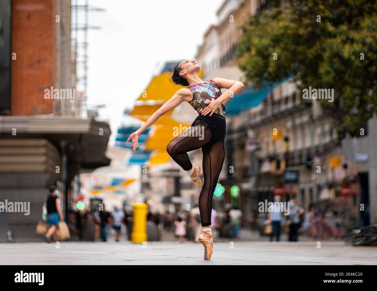 Ballerino che pratica ballare mentre si levano in piedi in piedi il tipoe sulla strada dentro città Foto Stock