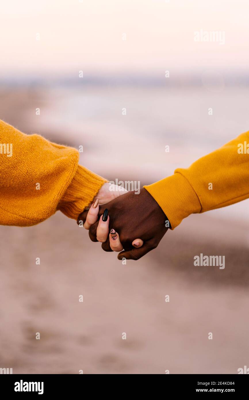 Primo piano di una coppia che tiene le mani in spiaggia Foto Stock