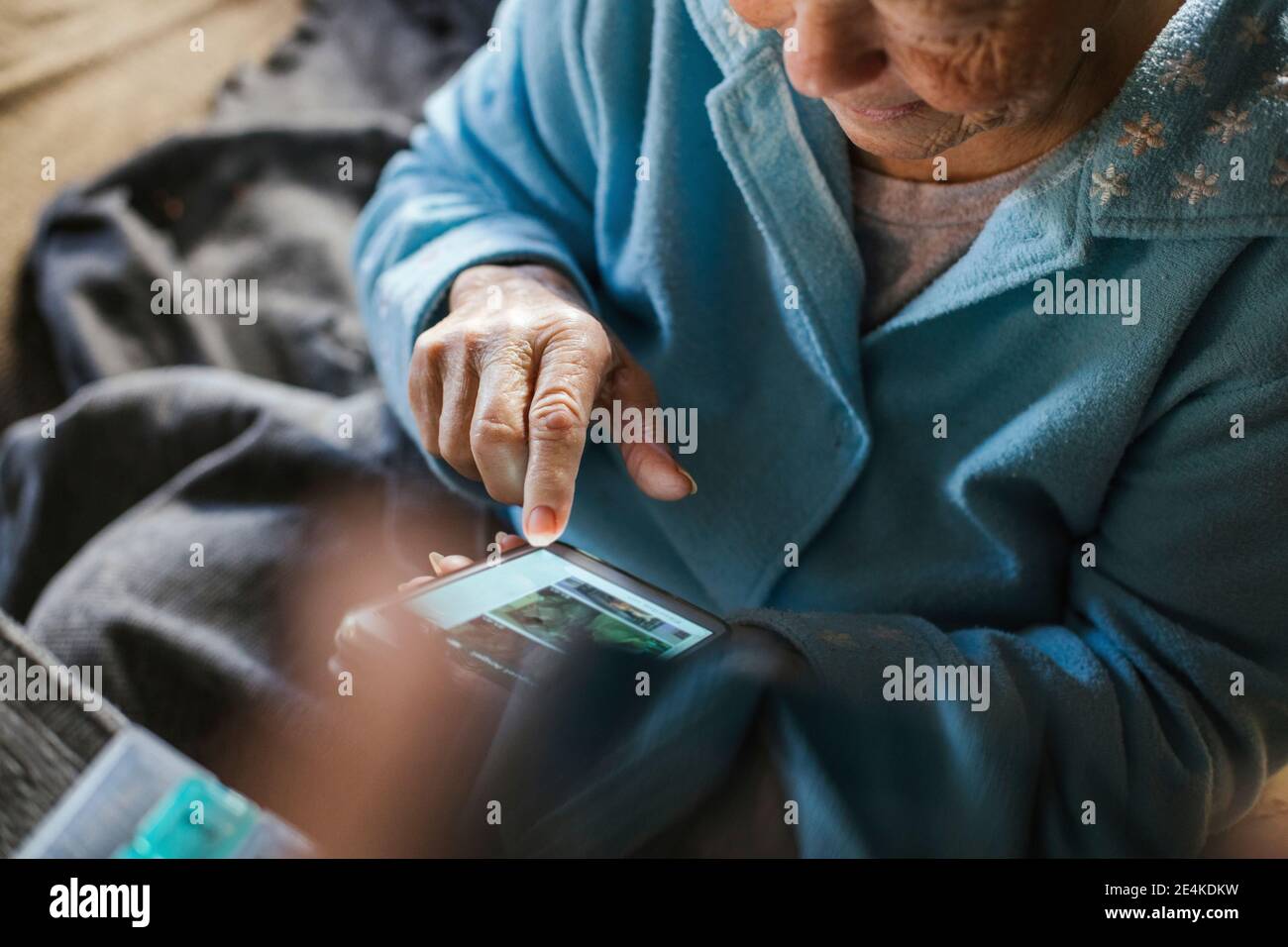 Messaggi di testo per le donne anziane su smartphone a casa Foto Stock