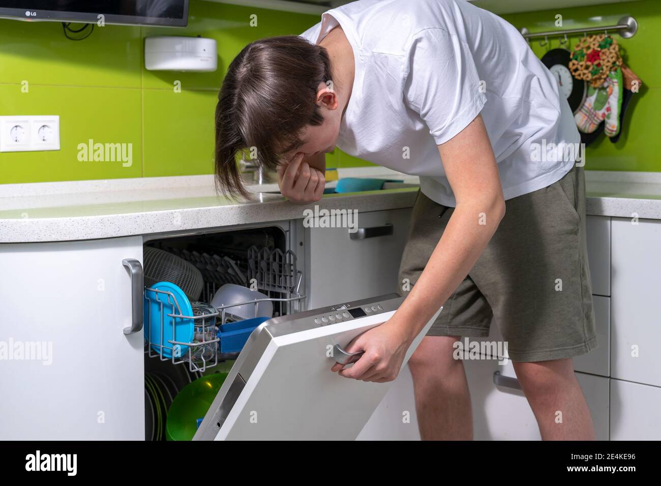l'uomo puzza di cattivo odore dalla lavastoviglie, problemi con cattivo  odore in cucina Foto stock - Alamy
