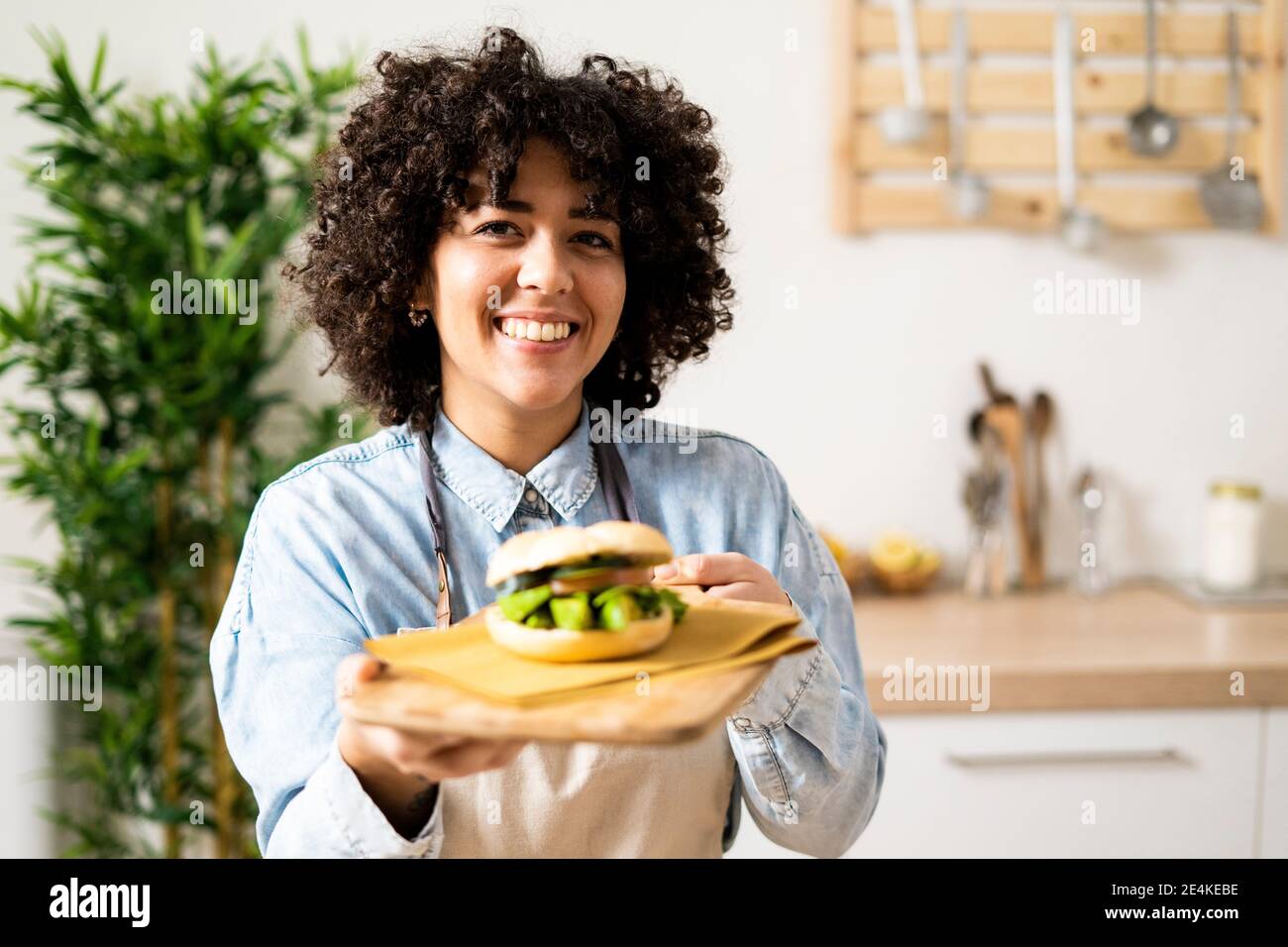 Ritratto di giovane donna che tiene fresco panino vegan Foto Stock