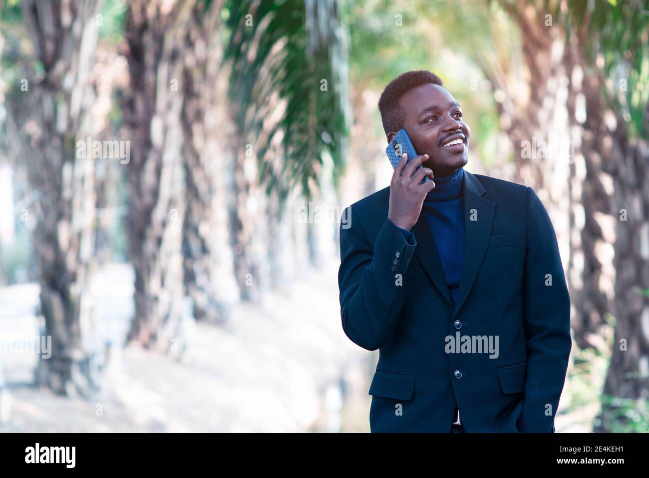 Uomo d'affari africano che utilizza lo smartphone Foto Stock