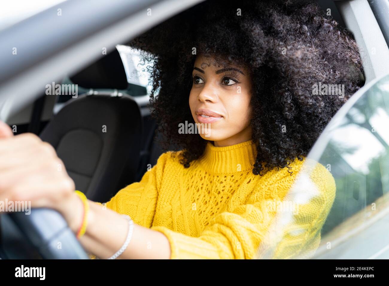 Giovane donna che si concentra durante la guida dell'auto Foto Stock