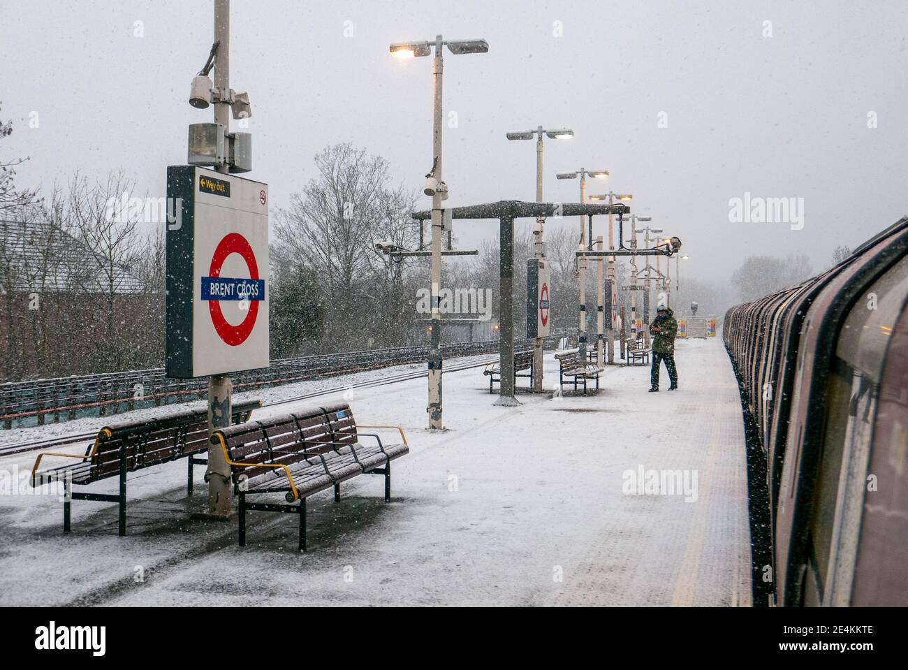 Un uomo solista esce o pervona il treno su una piattaforma innevata alla stazione della metropolitana di Brent Cross. La piattaforma è ghiacciata e coperta di neve a causa della mancanza di sale granato applicata dal trasporto per il personale londinese nonostante gli avvertimenti atmosferici. Londra. Regno Unito Meteo. Foto Stock