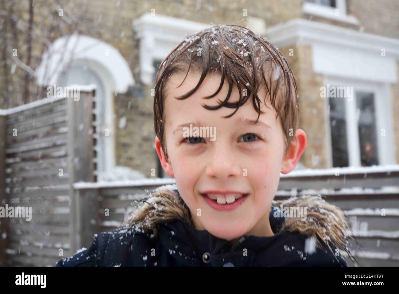 famiglia e vicini vicini condividono una doccia con una neve combattimenti dei bambini, i giorni invernali sono stati una pausa dopo il blocco durante la pandemia covida Foto Stock