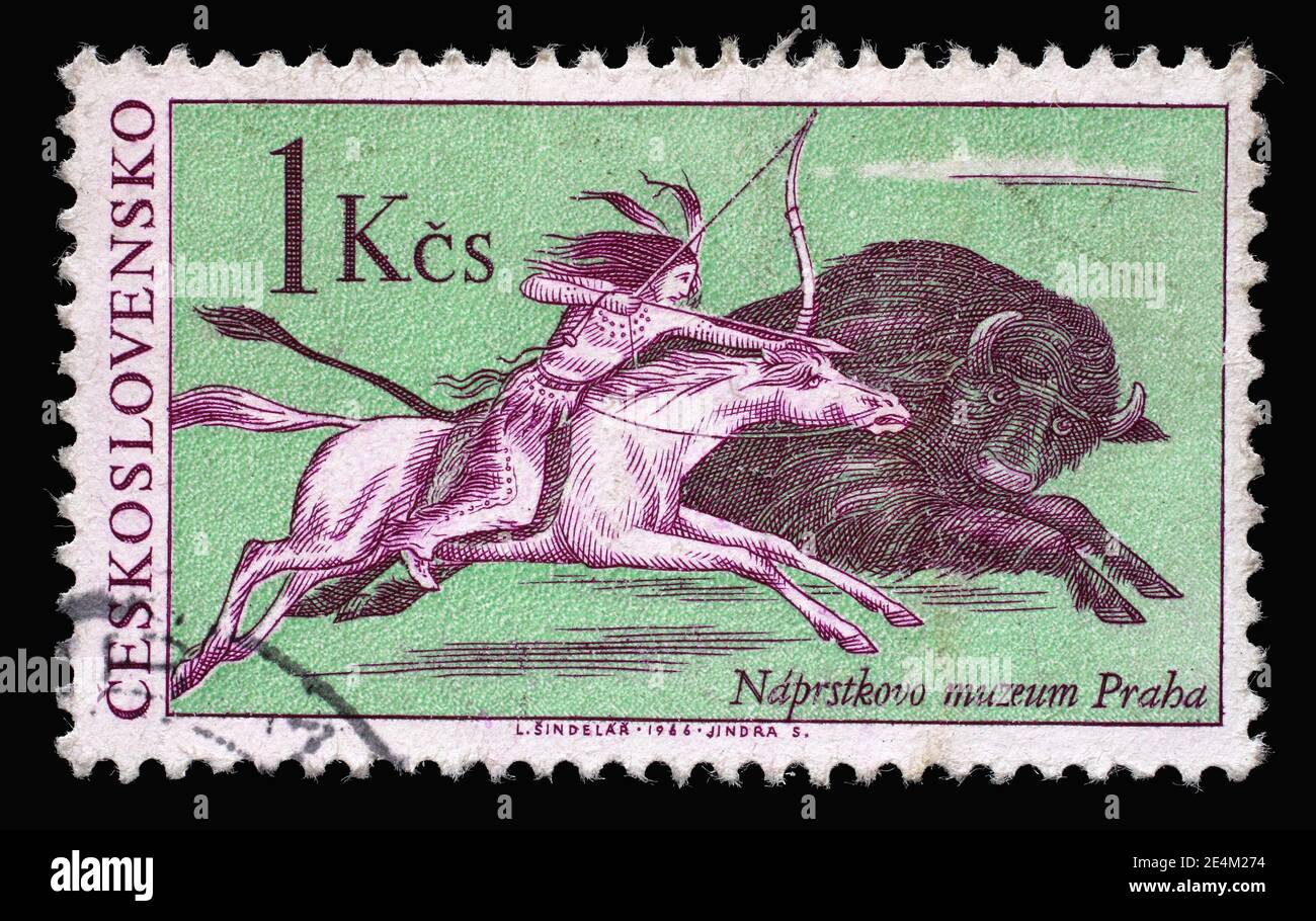 Il francobollo stampato in Cecoslovacchia mostra la scena della caccia ai bufali, un indiano nativo americano a cavallo, perseguono un galoppo di bisonti, circa 1966 Foto Stock