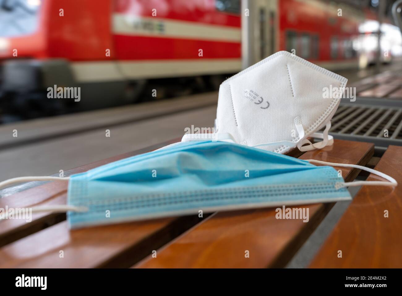 Maschera medica e maschera medica certificata FFP2 su banco in un'area di attesa di una piattaforma ferroviaria in una stazione. Protezione Covid monouso Foto Stock