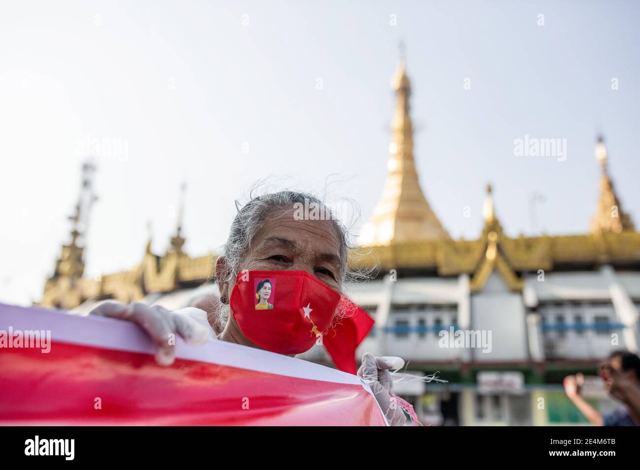 Yangon, Birmania. 24 gennaio 2021. Una donna anziana che indossa una maschera NLD (Lega Nazionale per la democrazia) ha un banner durante la protesta.la gente partecipa a un raduno a sostegno del nuovo governo e della Commissione elettorale dell'Unione a Yangon. Credit: SOPA Images Limited/Alamy Live News Foto Stock