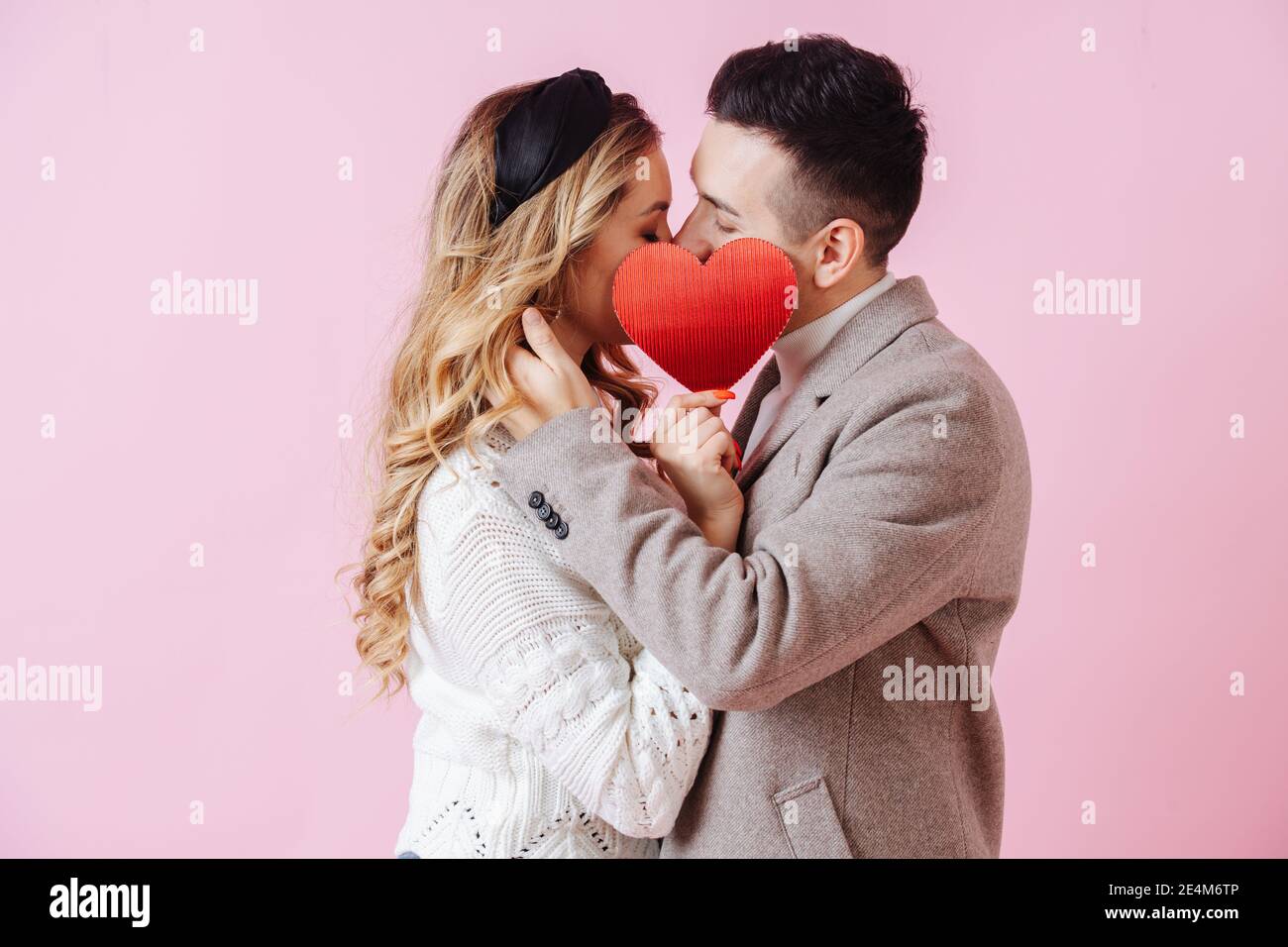 San Valentino. Bacio di coppia nascosto dal cuore rosso Foto Stock