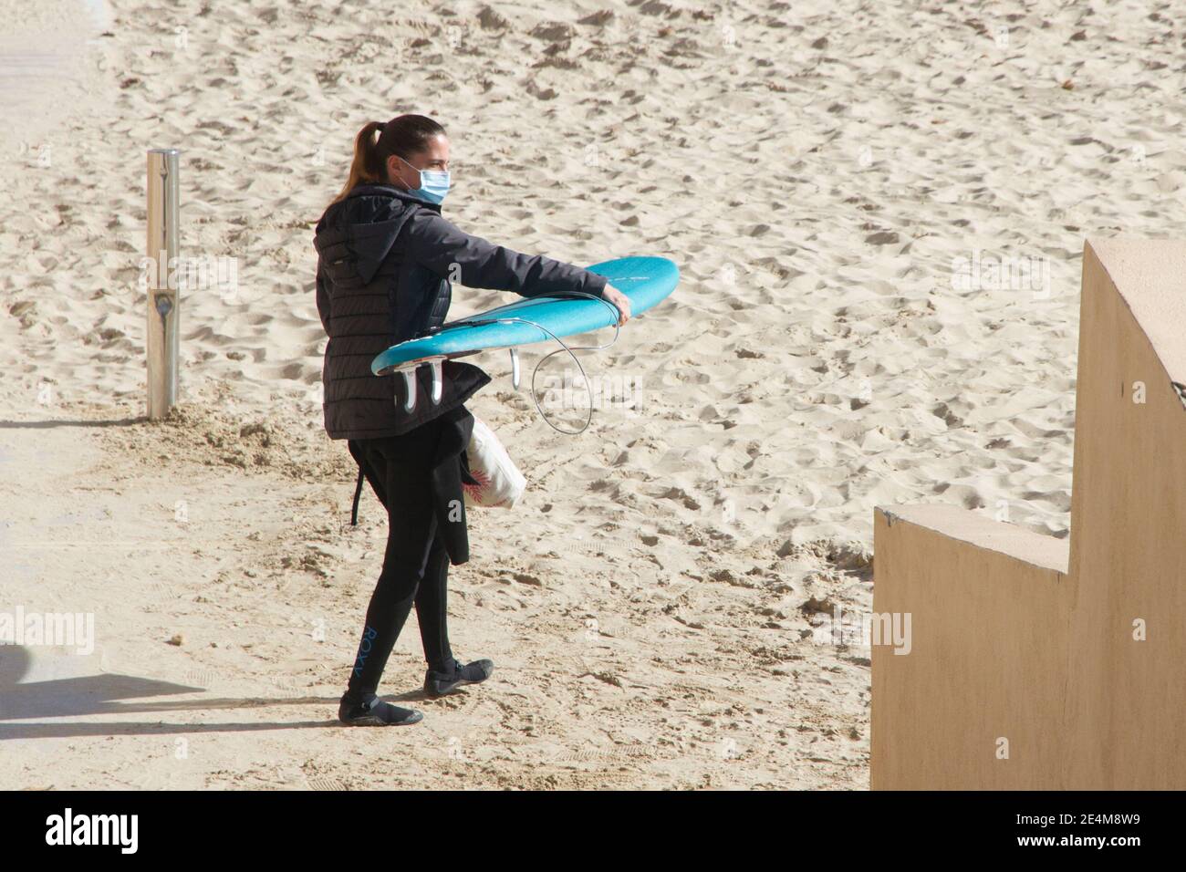 Post Covid Surfer donna portare surf maschera Covid Foto Stock