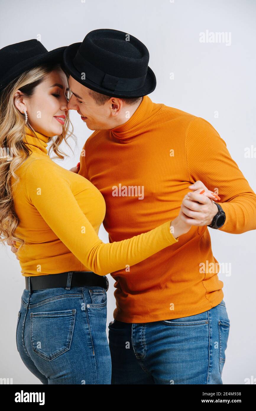 Ballerini in cappelli neri e abiti arancioni luminosi Foto Stock