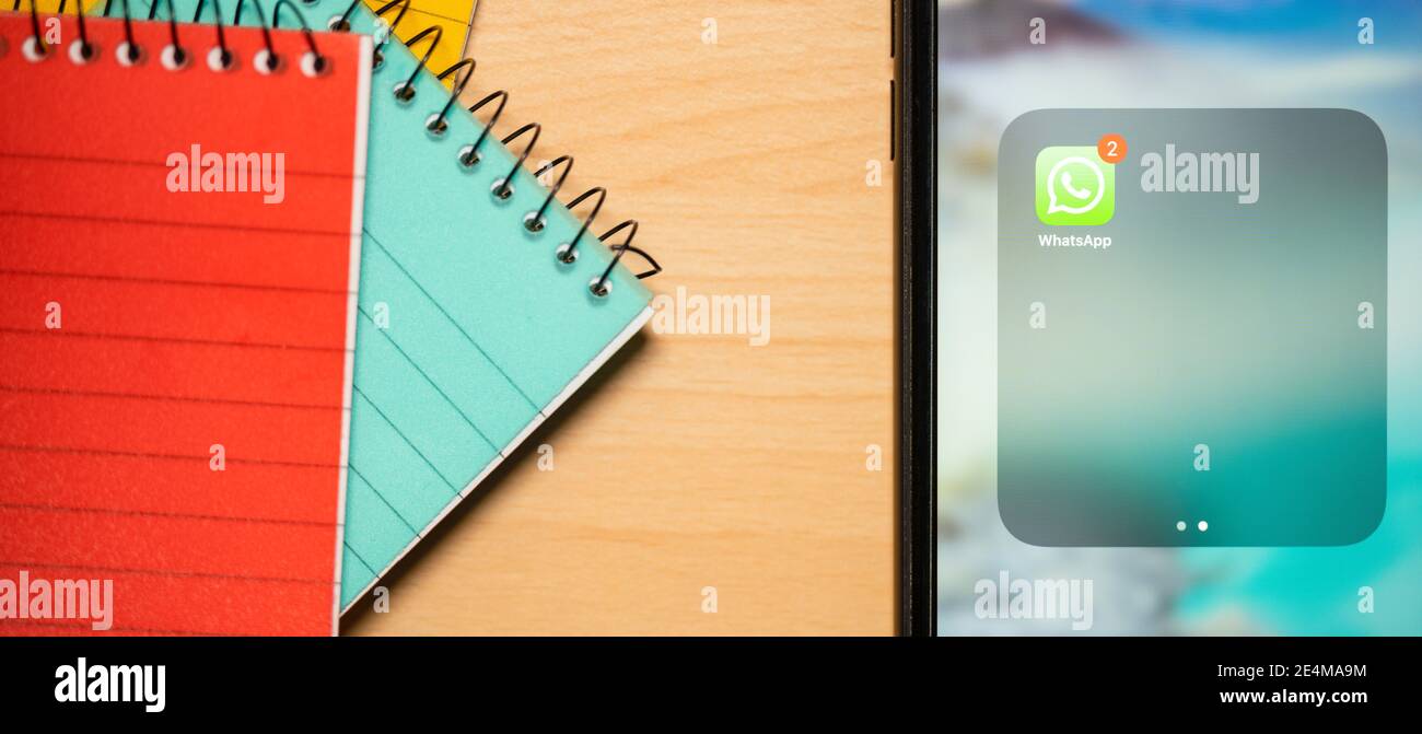 Roma, Italia, 24 gennaio 2021. Alcuni notepad e uno smartphone con l'app Whatsapp su una scrivania. Foto Stock