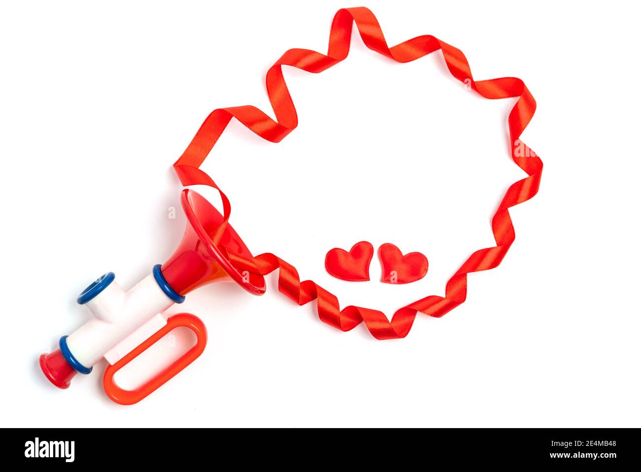 I cuori rossi e la cornice del nastro fuori dal tubo del giocattolo dei bambini. Il concetto di una canzone d'amore di San Valentino per amore. Foto Stock