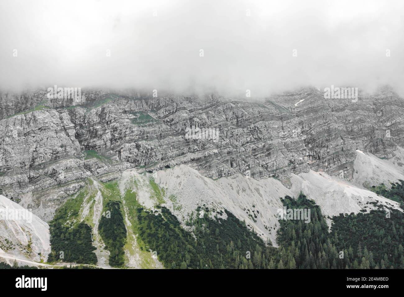 Drone aereo scatto di roccia scogliera di Zugspitze coperto con Nebbia pesante in Germania Foto Stock