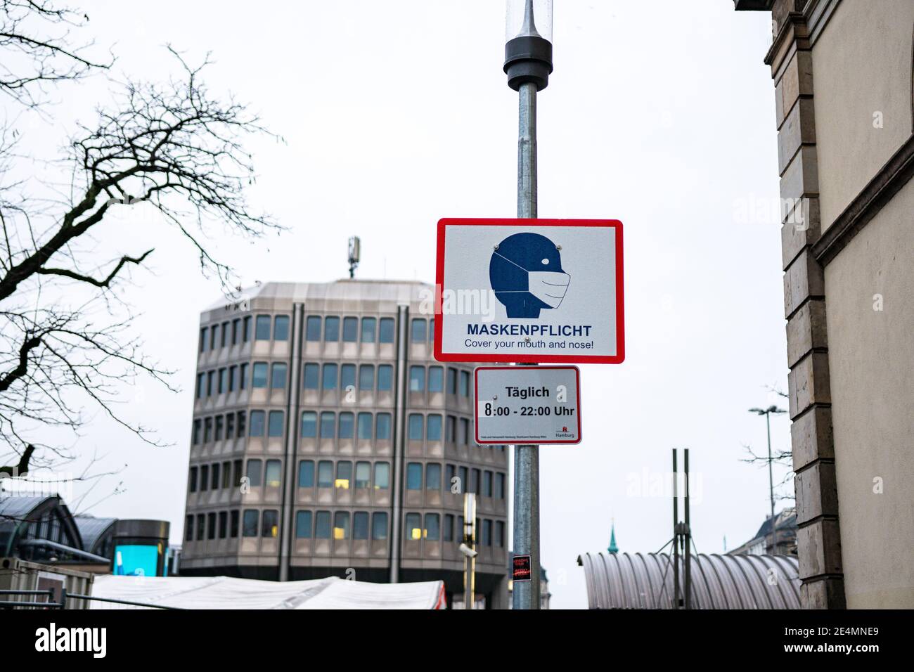 Amburgo, Germania - Gennaio: Un cartello di fronte alla stazione ferroviaria principale ricorda che c'è un requisito di maschera a causa di corona e covid-19. Foto Stock