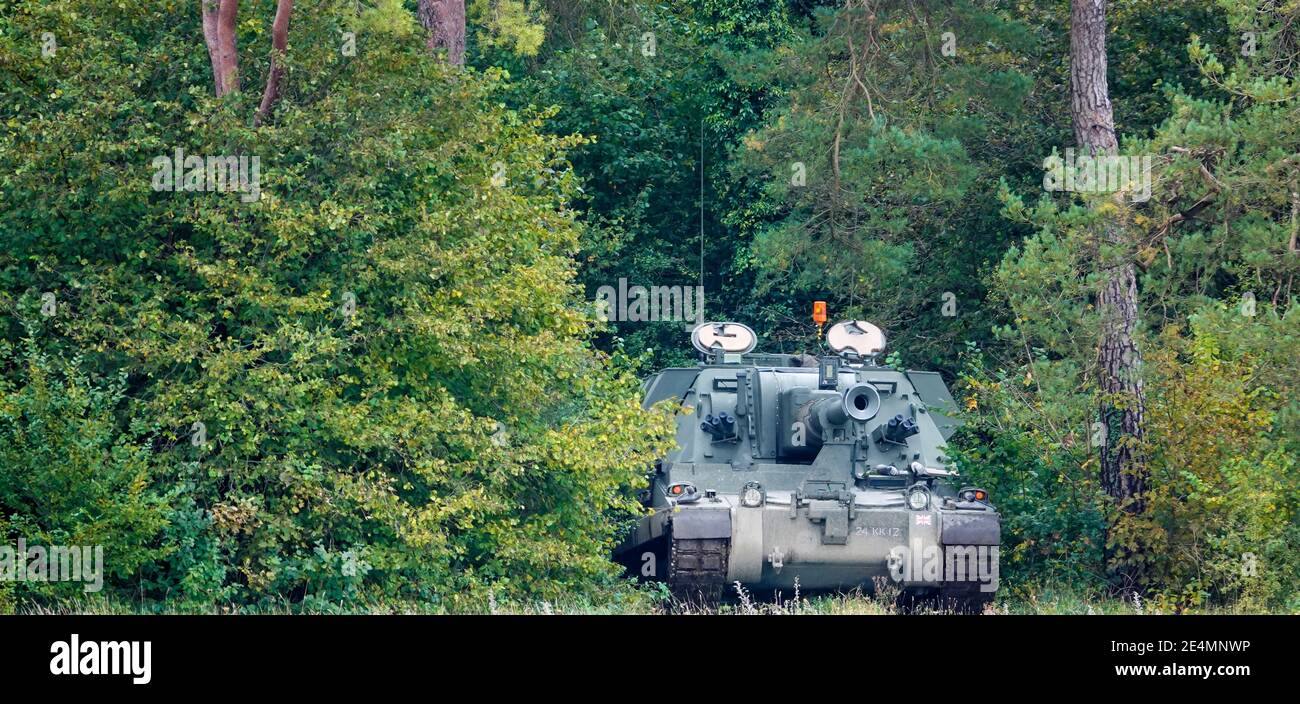Cannone obice semovente dell'artiglieria semovente AS-90 del British Army mimetizzato tra la copertura degli alberi Foto Stock