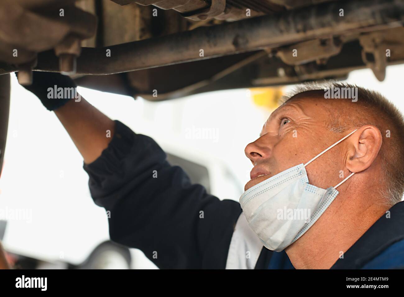 Un meccanico auto ripara un'auto. Un meccanico attento fa il lavoro Foto Stock
